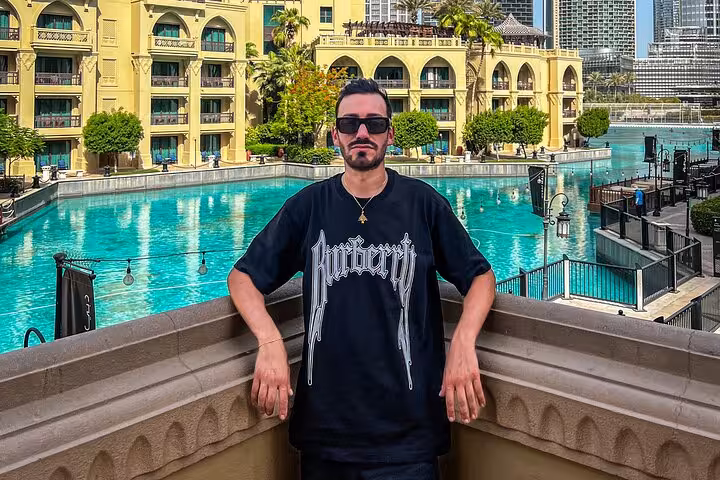 Man posing near stunning Dubai hotel pool, perfect for layover Instagram videography tour.