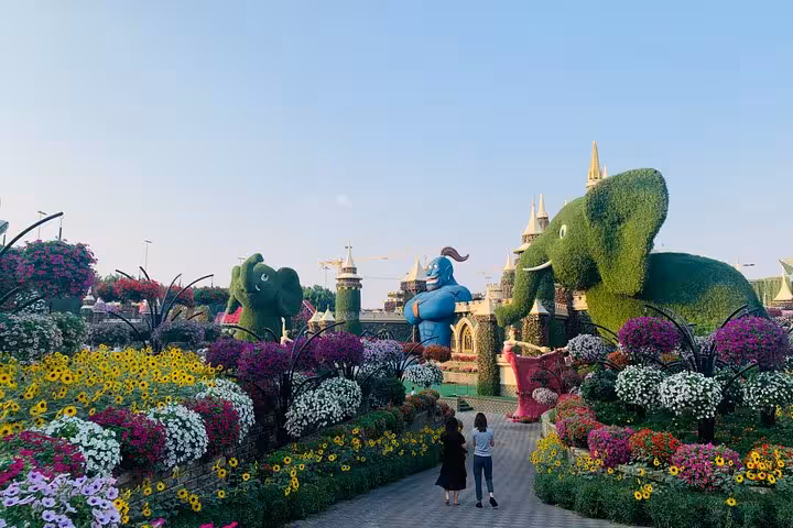 Dubai Miracle Garden pathway with elephant topiary and colorful blooms, Global Village combo from Fujairah