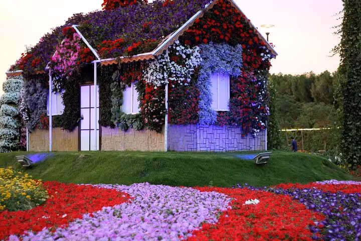 Flower-covered cottage at Dubai Miracle Garden with colorful blooms, entry pass ticket from Dubai tour