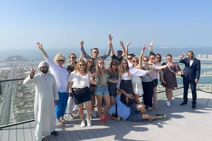 Happy group photo on The View at The Palm observation deck during Palm Jumeirah tour, entrance included Dubai