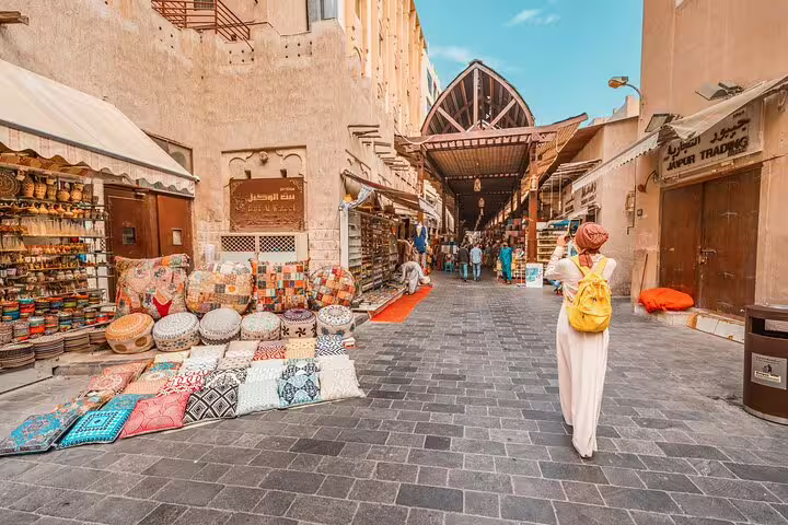 Private full-day Dubai customizable tour through Al Seef souk walkway with textiles, cushions, and heritage shops