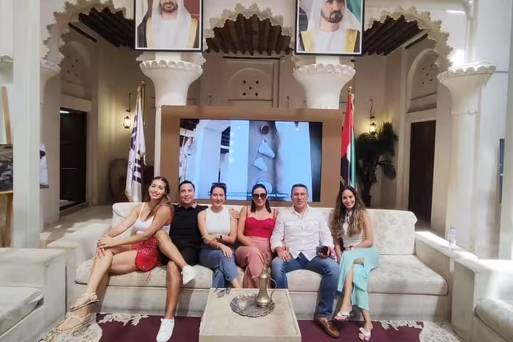Tour group relaxing in traditional Dubai heritage lounge before pickup and drop-off transfer to Fujairah