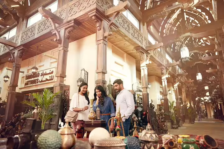 Tourists exploring a traditional market on a Dubai full-day city sightseeing tour in a private vehicle.
