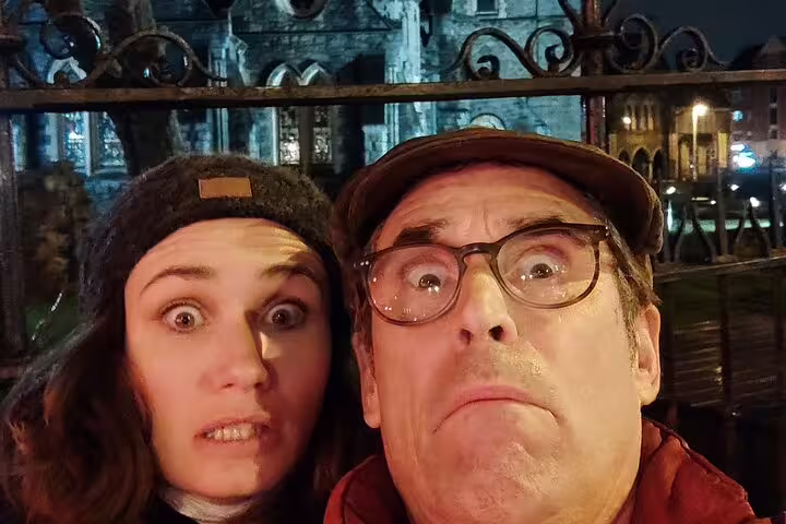 Two people making scared faces on Dublin haunted walking tour at night near historic building