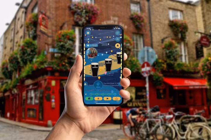 Hand holding a tour guide app showing Dublin hidden gems map near vibrant Temple Bar street in Ireland