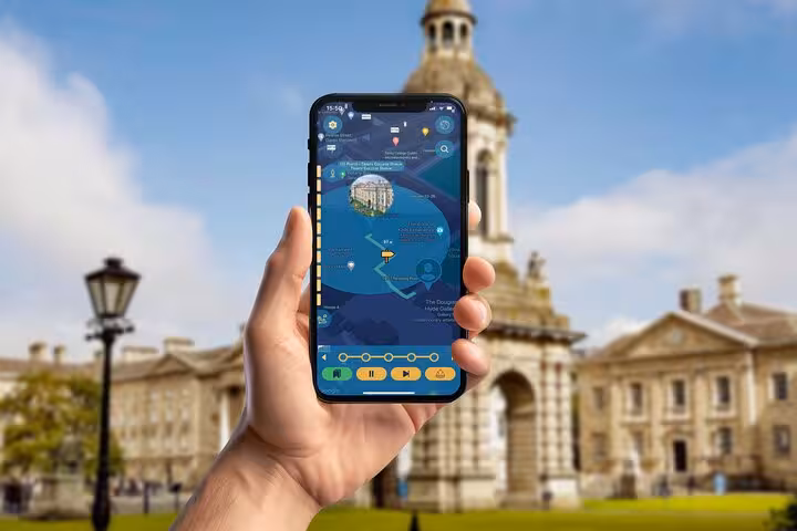 Hand holding a smartphone with Dublin walking tour app map in front of Trinity College hidden gems route