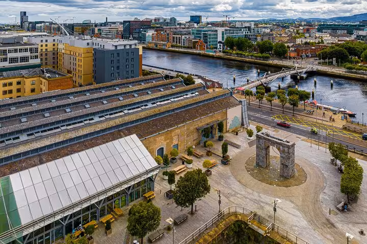 Aerial view of Dublin's Grand Canal Dock with stone archway, River Liffey, and city skyline