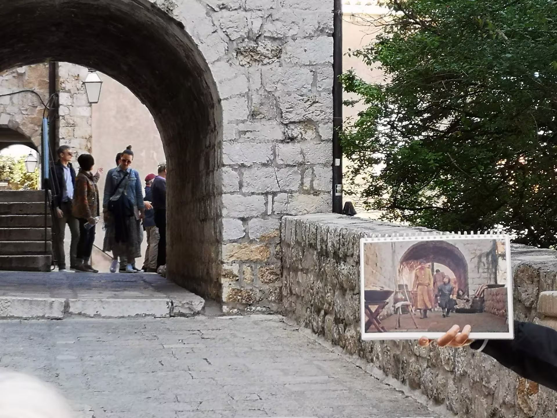 Dubrovnik Game of Thrones walking tour at stone archway, guide shows King’s Landing scene photo