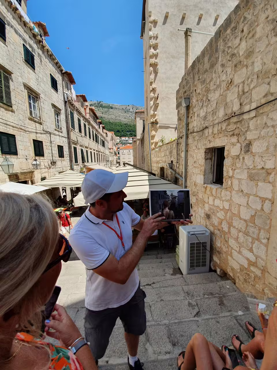 Dubrovnik Game of Thrones walking tour guide shows filming scene on tablet on Old Town stone steps