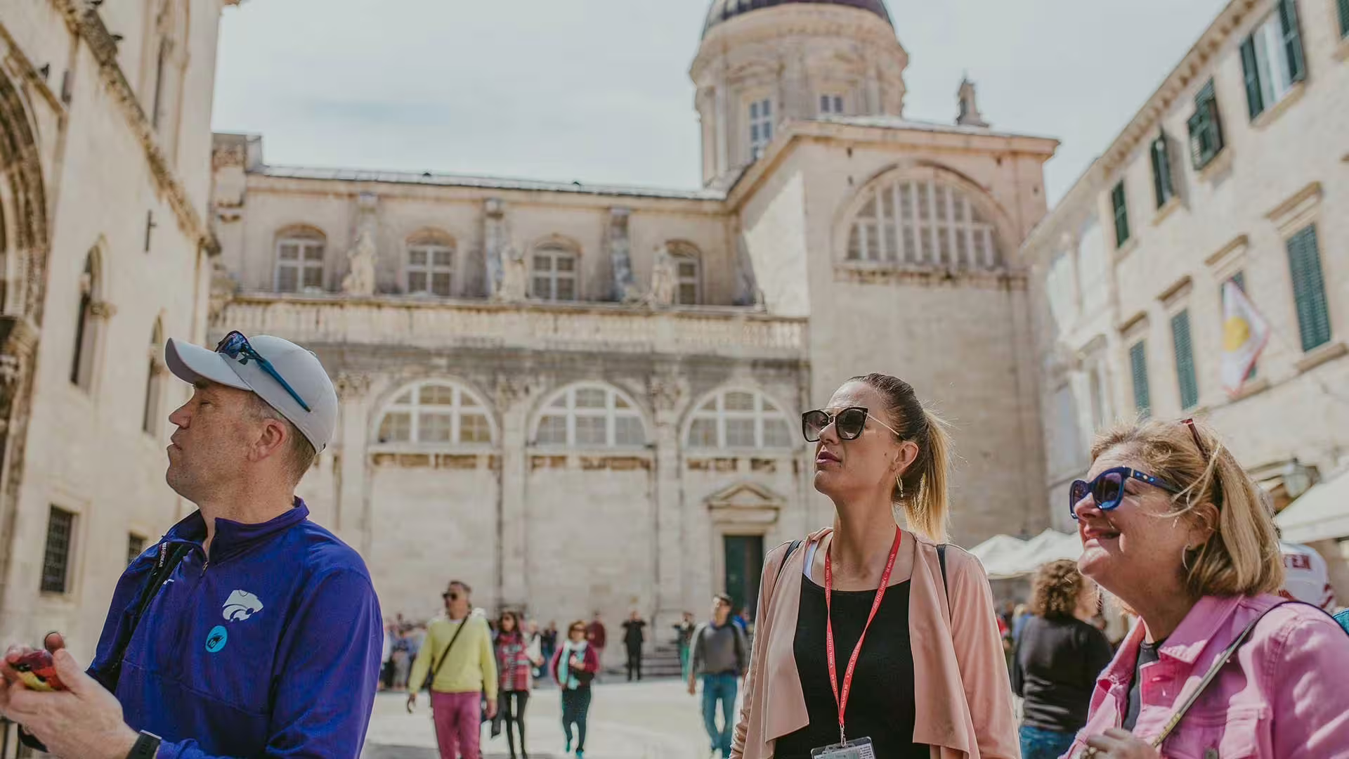Guided Old City group walking tour in Dubrovnik, travelers listening in front of historic cathedral