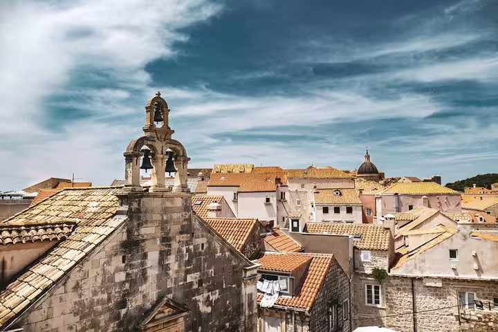 Dubrovnik Old Town skyline with historic church bell tower and terracotta roofs, seen from the ancient city walls