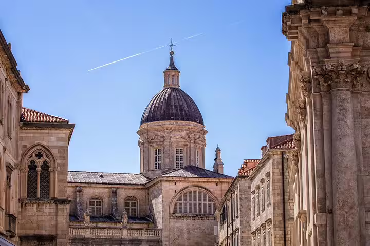 Dubrovnik Old Town cathedral dome framed by stone streets, highlight on City Walls walking group tour