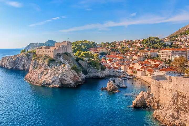 Aerial view of Dubrovnik Old Town with historic stone walls, fortress, and terracotta rooftops along the Adriatic Sea