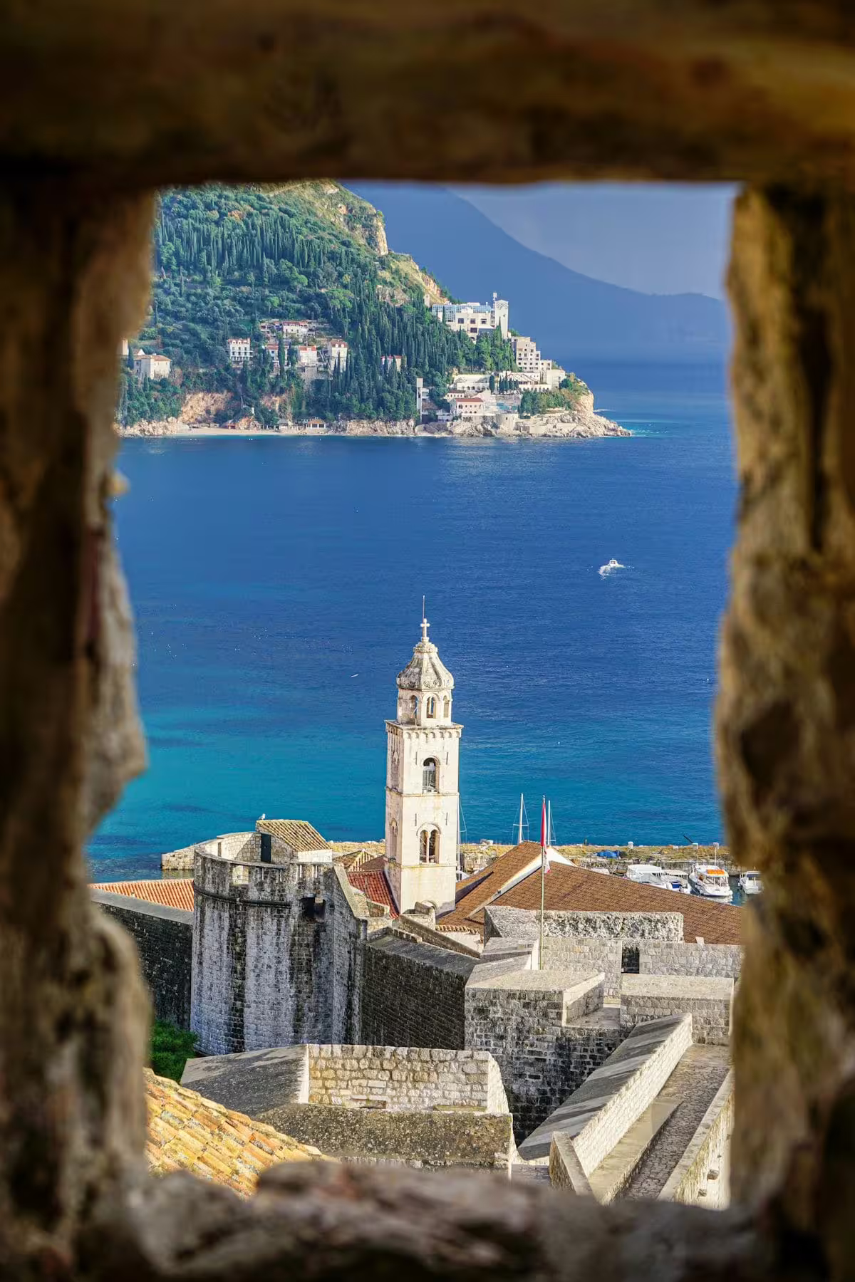 View through fortress window to Dubrovnik Old Town bell tower and Adriatic coast on a private tour