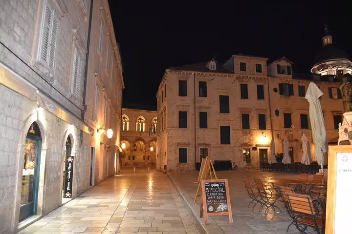 Quiet Dubrovnik Old Town square at night with lit stone buildings, atmosphere on a Dubrovnik by night group walk