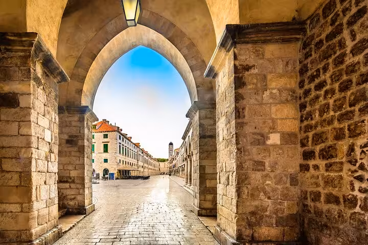 Stone archway leading to Stradun main street in Dubrovnik Old Town with historic buildings