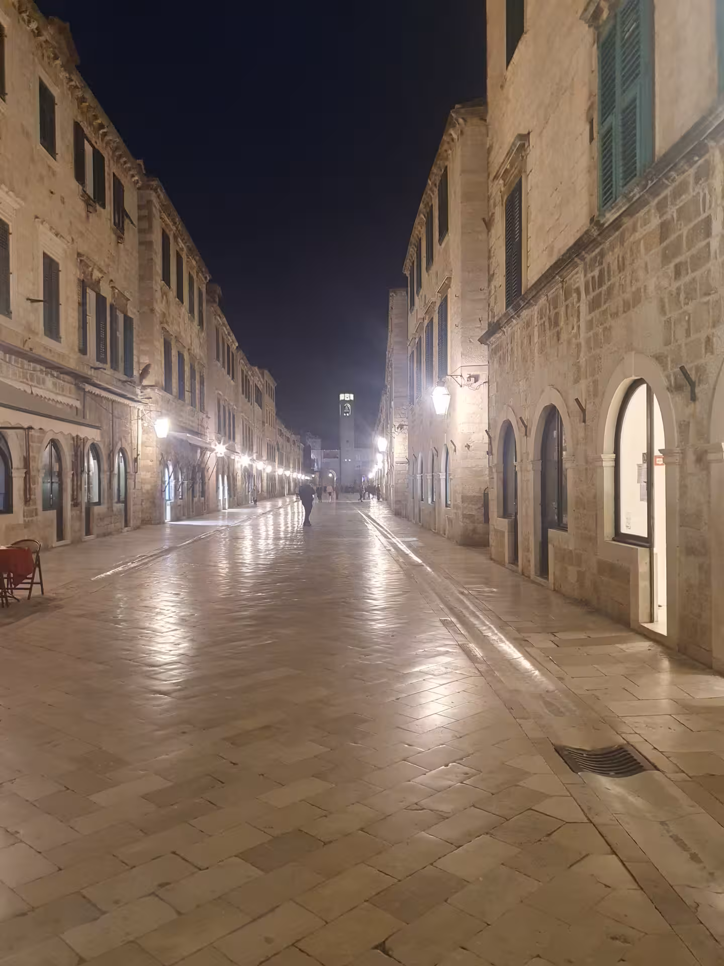 Night walk on Stradun in Dubrovnik Old Town, lantern-lit limestone street on the history by night tour