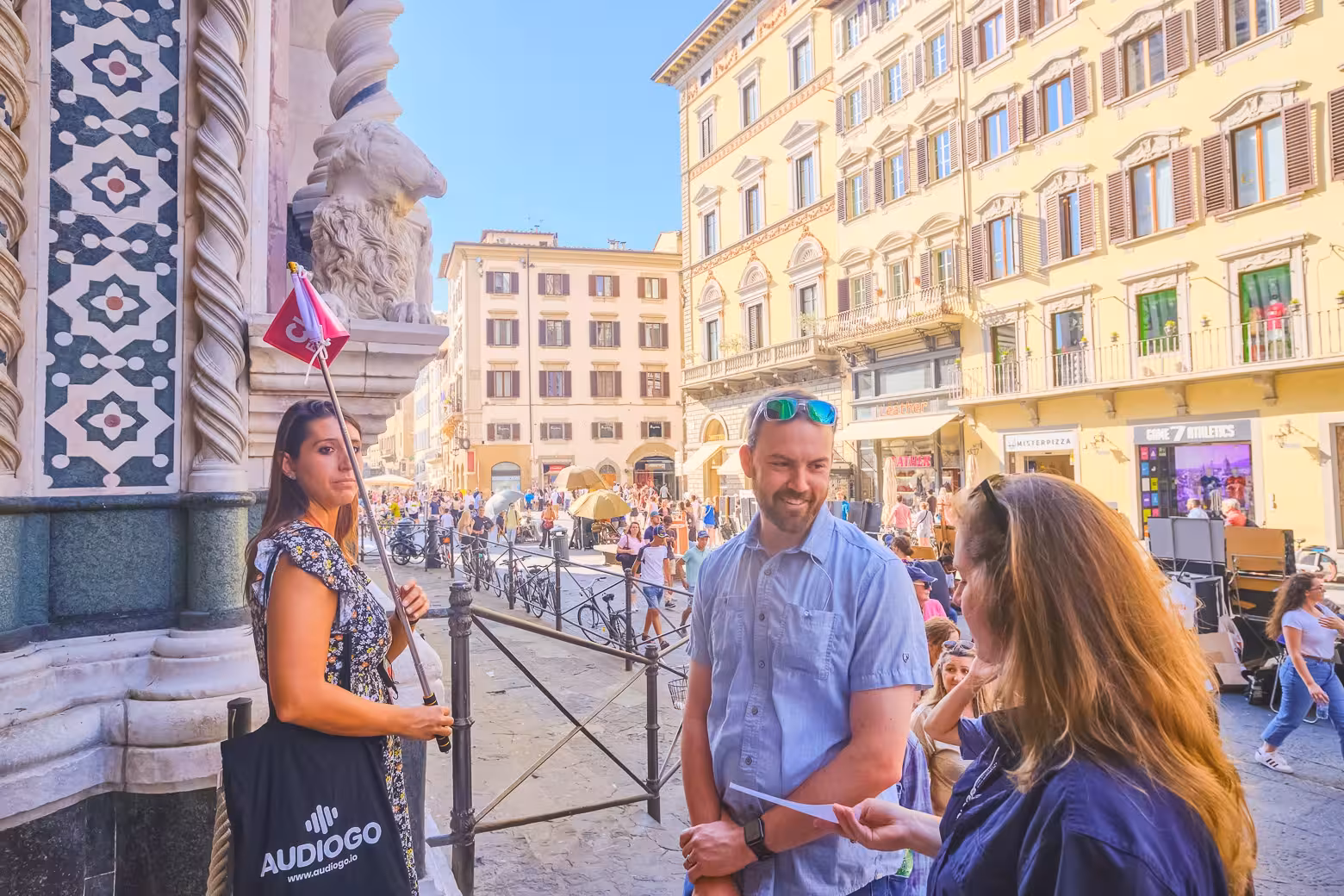Visitors engage with a guide outside the Duomo Complex, capturing the lively atmosphere of Florence's historic center.