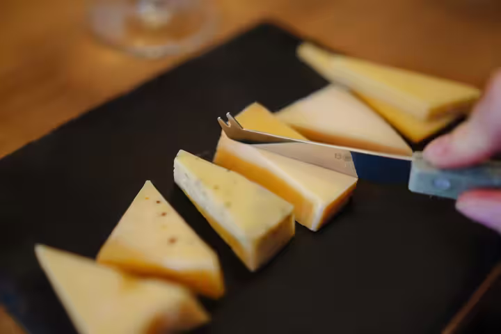 Selection of Dutch cheeses on a slate board, featured in the Amsterdam Walking Tour with Cheese Tasting experience.