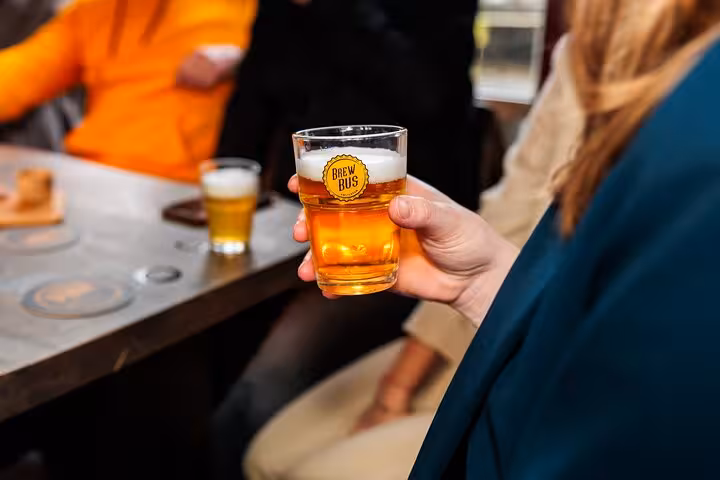 Close-up of Dutch craft beer glass on guided Amsterdam beer tasting with cheese and sausage in a brewery bar