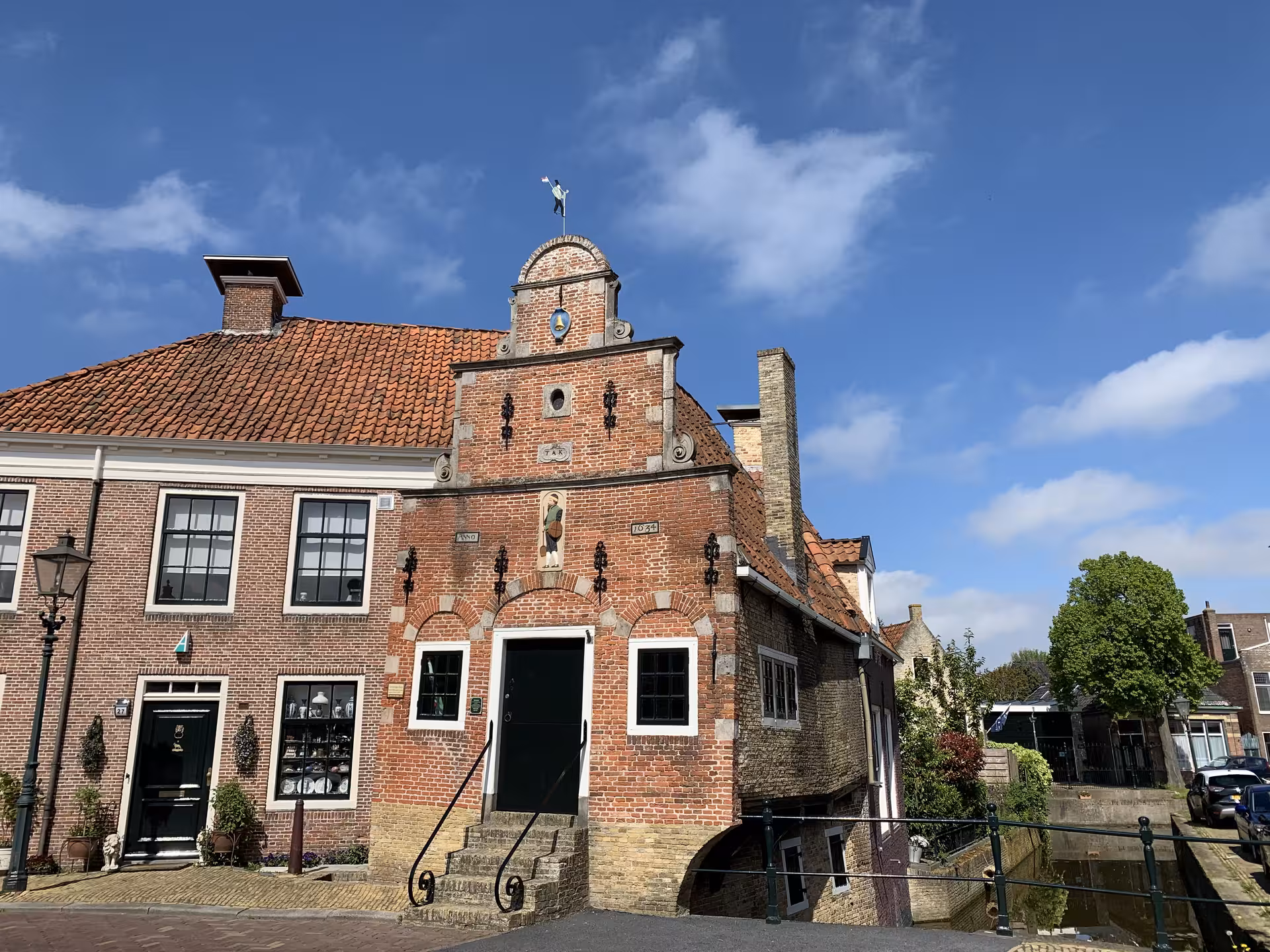 Historic brick gabled house and canal in a Dutch village, cultural heritage stop on private tour from Noordwijk