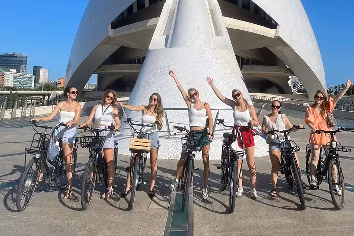 Dutch-guided Valencia bike tour group with bicycles at City of Arts and Sciences on a sunny day