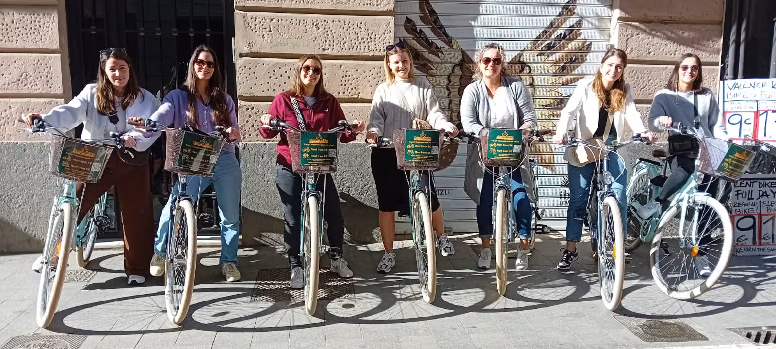Group of friends posing with Dutch-style Omafiets city bike rentals, classic step-through bikes with baskets