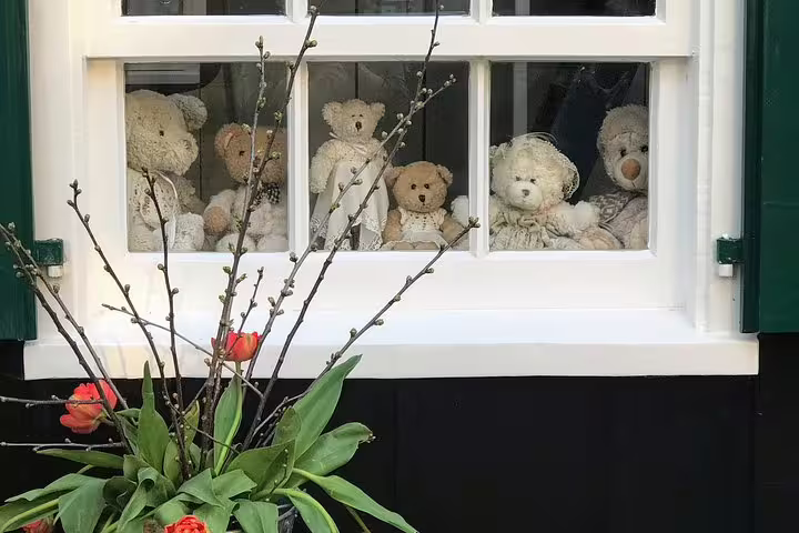 Dutch village window with teddy bears and spring tulips, a charming stop on an Amsterdam countryside bike tour