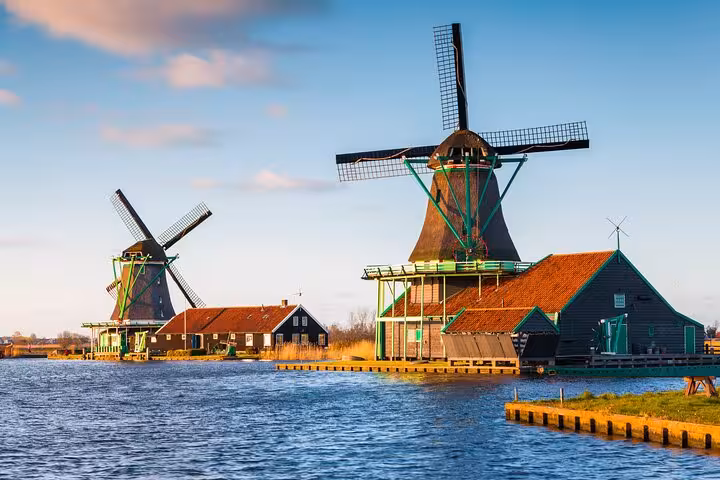 Traditional Dutch windmills by the water at Zaanse Schans, classic highlight on Discover The Netherlands tour from Amsterdam