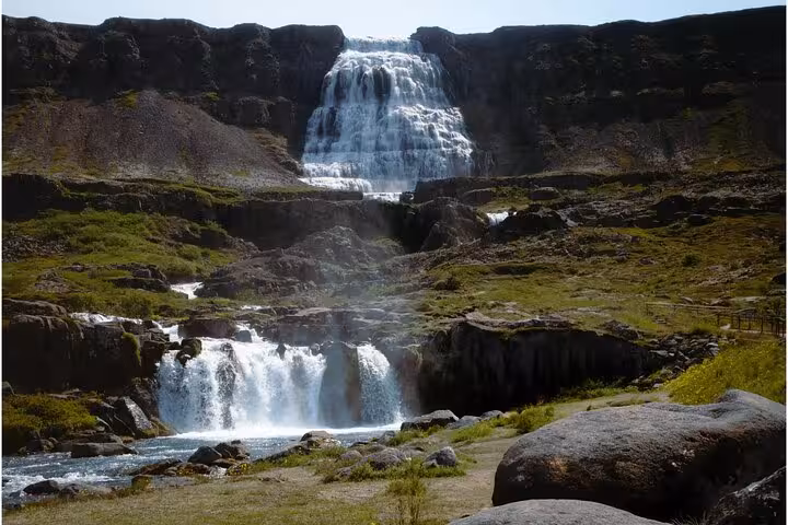 Dynjandi waterfall cascading down rocky cliffs in the Westfjords of Iceland on a sunny day