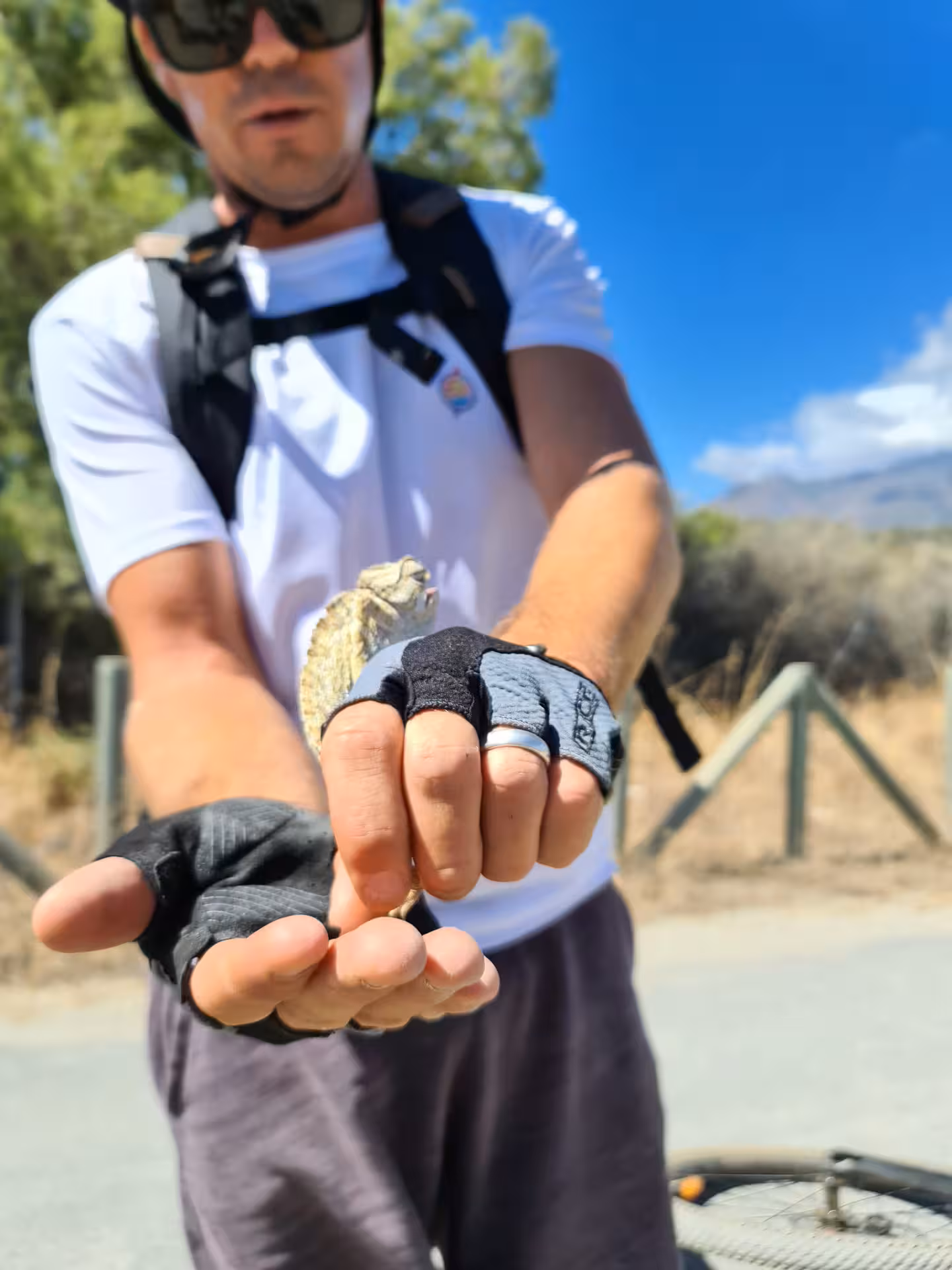 E-bike tour guide holding a small lizard discovered along the scenic Sierra Bermeja nature trail near Estepona