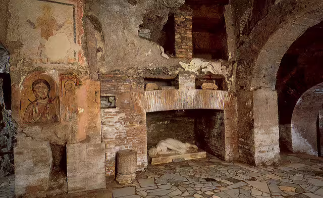 Early Christian burial chamber in the Catacombs of Rome with frescoes, brick arches and marble sarcophagus
