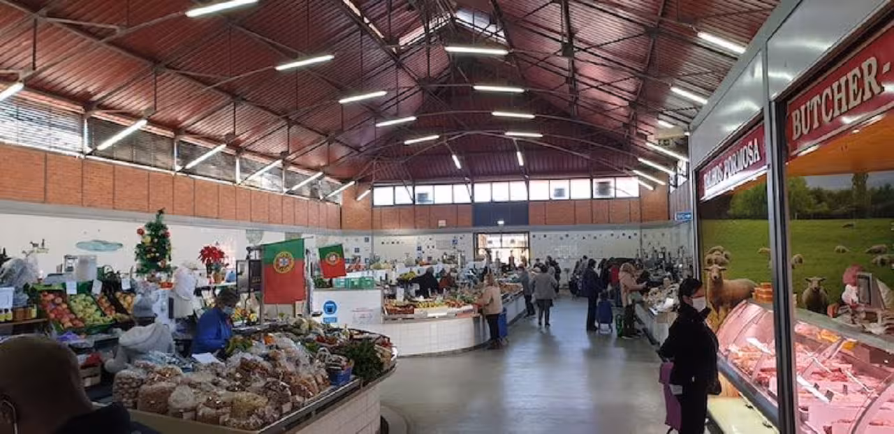 Traditional Eastern Algarve indoor market with Portuguese flags, butchers and produce stalls visited on a full-day tour.