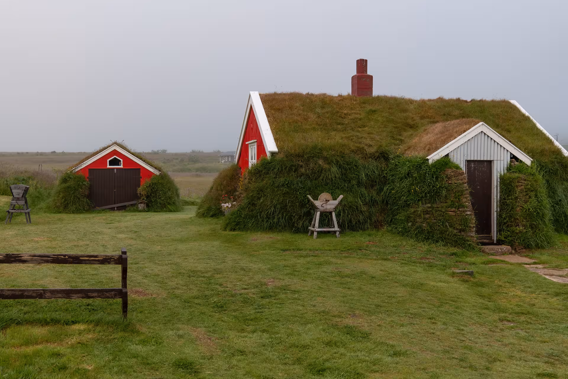 Traditional Icelandic turf houses with grass roofs and red wooden facades in the Eastfjords region