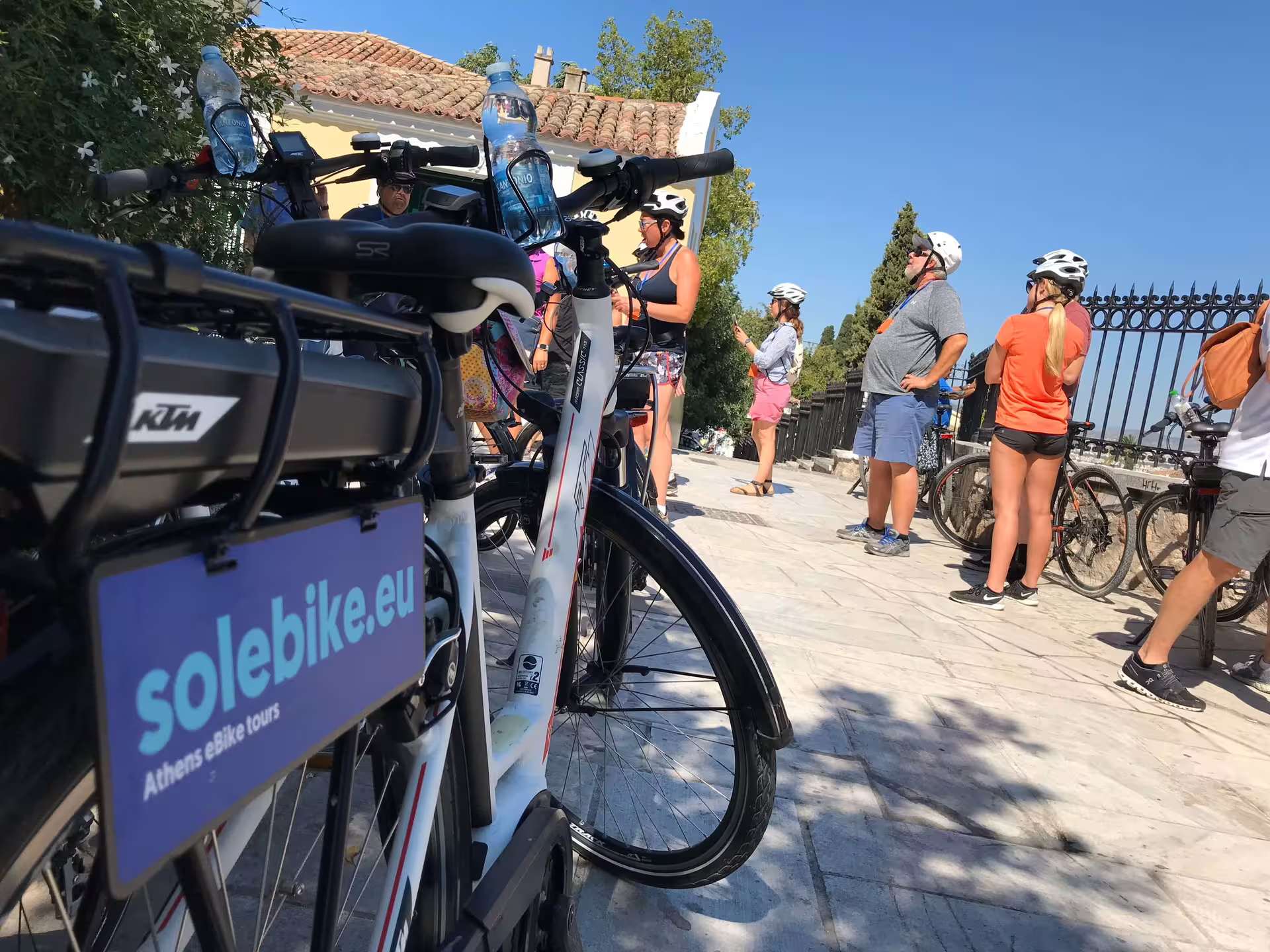 E-bikes ready for an Athens tour with participants in helmets, highlighting sustainable travel and adventure.