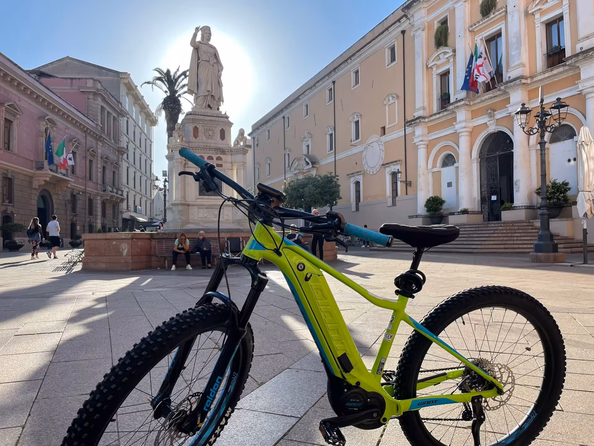 E-bike parked in Oristano's historic square, Sardinia, highlighting cultural landmarks for an enriching cycling tour.