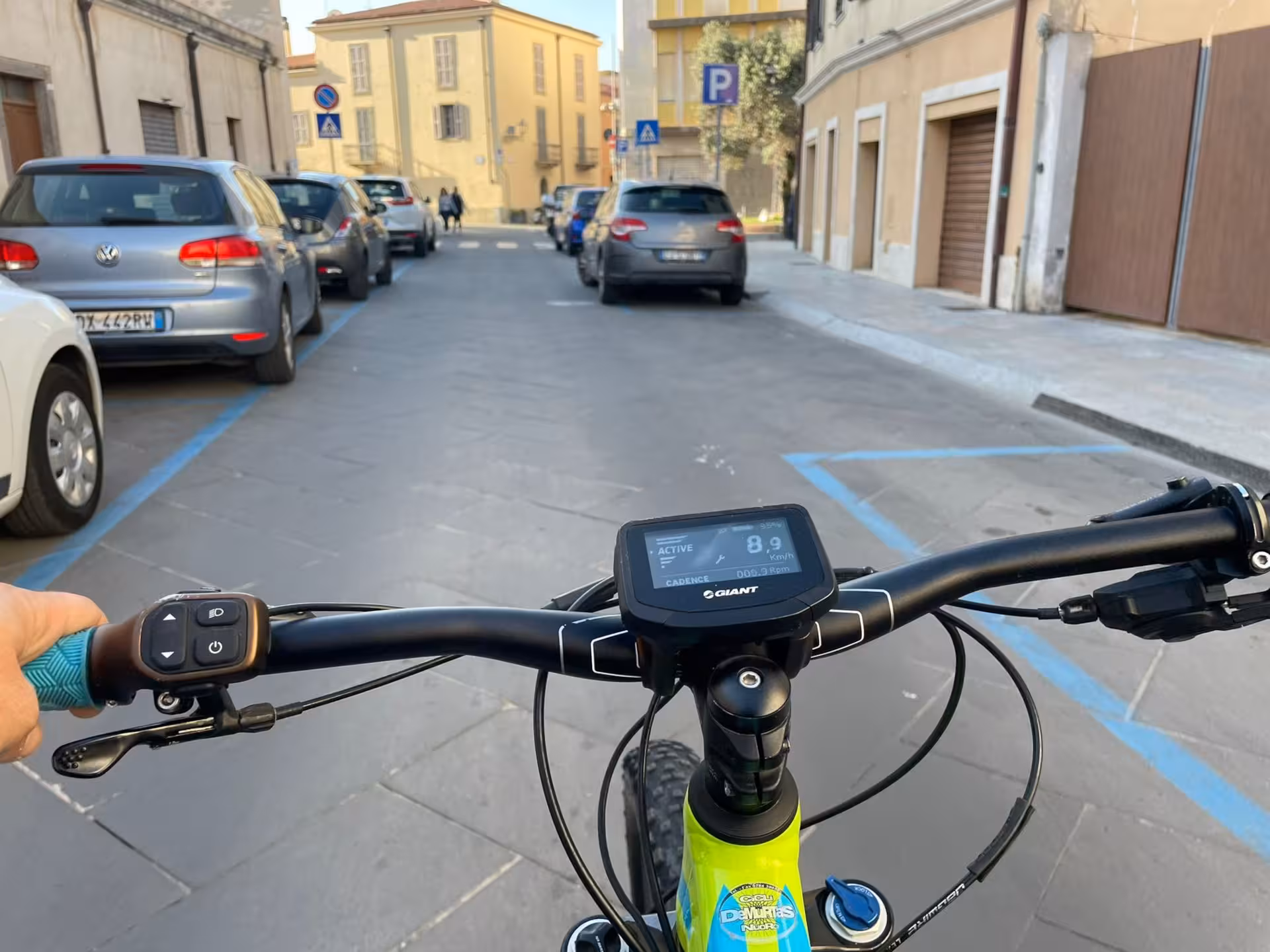 View from an e-bike in Oristano, Sardinia, showcasing a scenic urban street perfect for holiday cycling adventures.