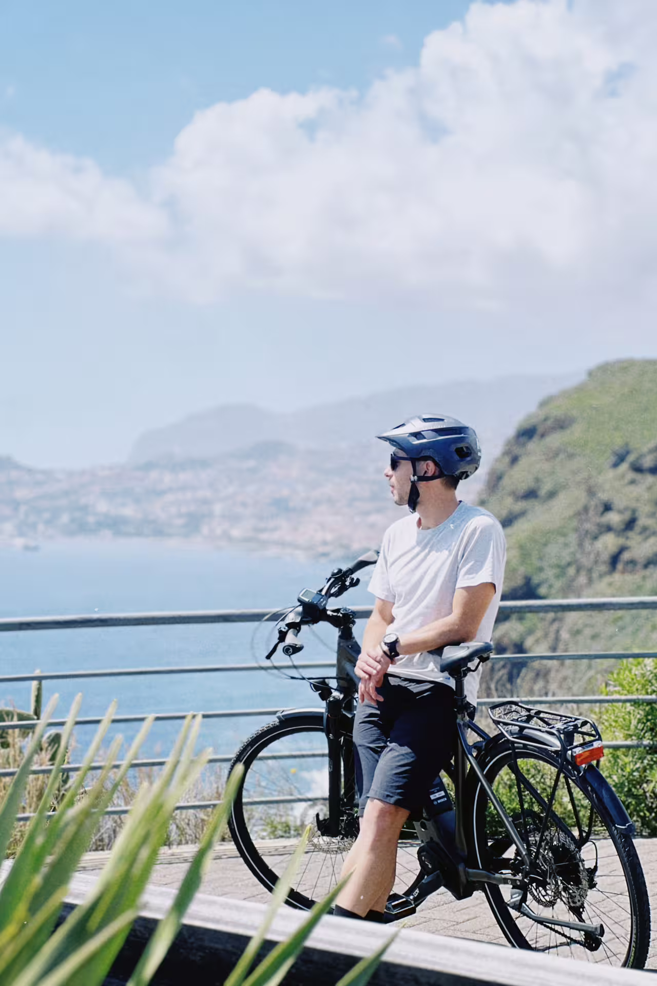 Cyclist enjoying scenic ocean view on a self-guided e-bike road tour from Funchal to Garajau, Madeira.