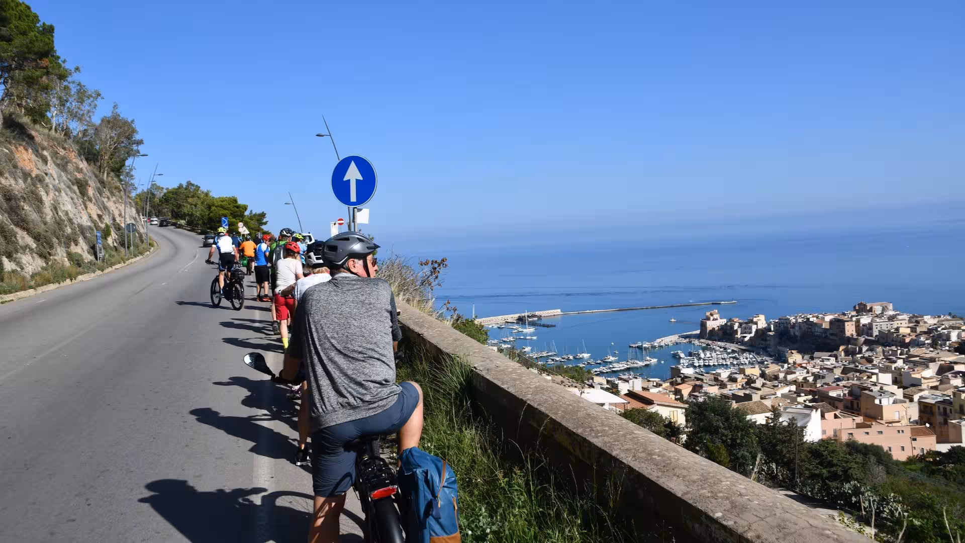 Cyclists enjoy breathtaking coastal views of Erice on an e-bike tour, overlooking the sparkling Mediterranean Sea.