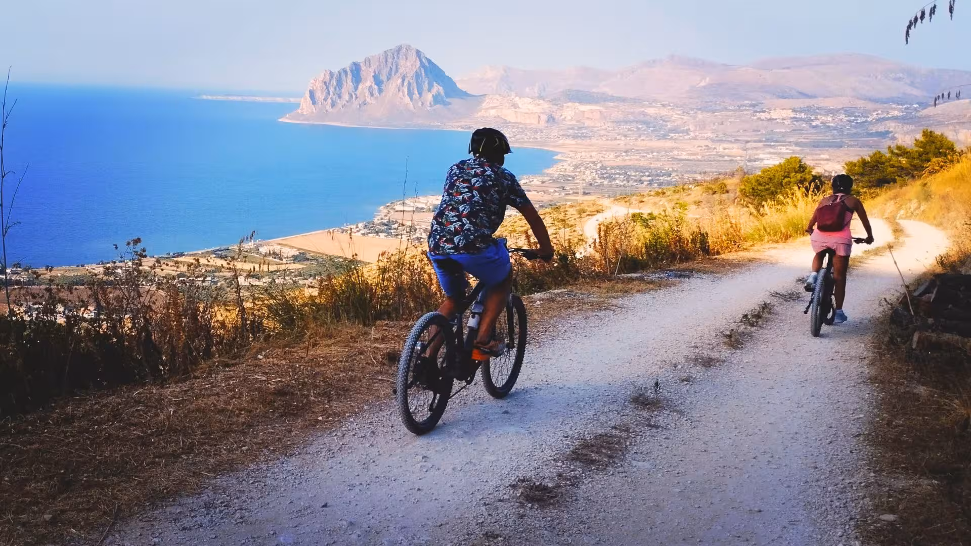 Cyclists enjoying a scenic ebike tour in Erice with breathtaking views of the coastline and mountains near Trapani.