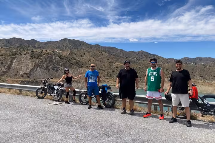 Group stops with e-fat bikes on a scenic mountain road during Malaga Montes off-road e-bike tour