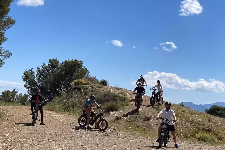 Group riding e-fat bikes on a Malaga off-road tour in the Montes, tackling rocky trails with mountain views