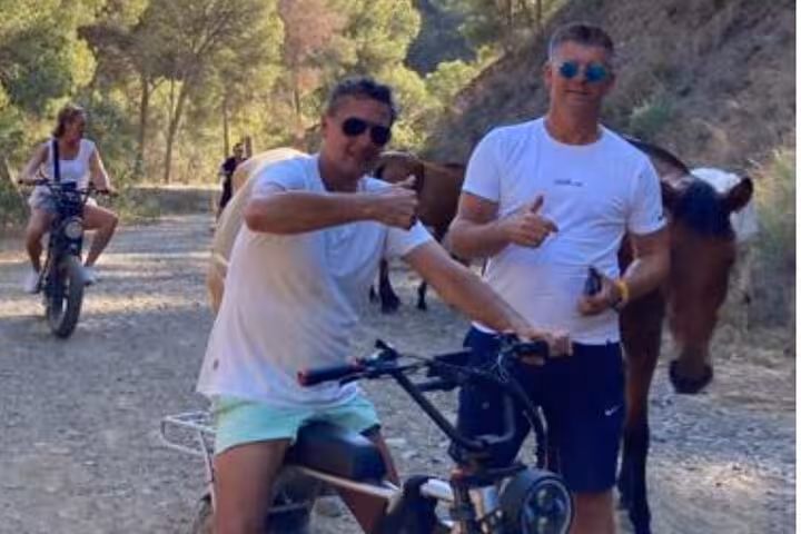 Off-road e-fat bike tour in Montes de Málaga passing horses on a forest trail, fun Malaga e-bike ride