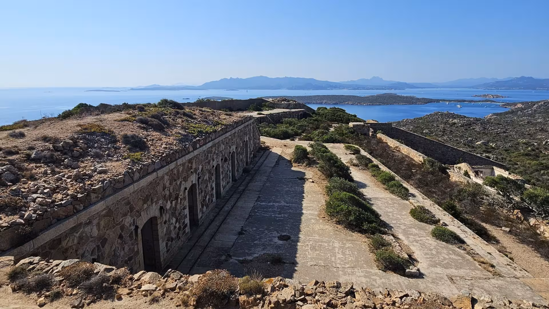 Explore historic stone ruins overlooking serene sea views on an e-bike tour from Palau to Caprera or La Maddalena.