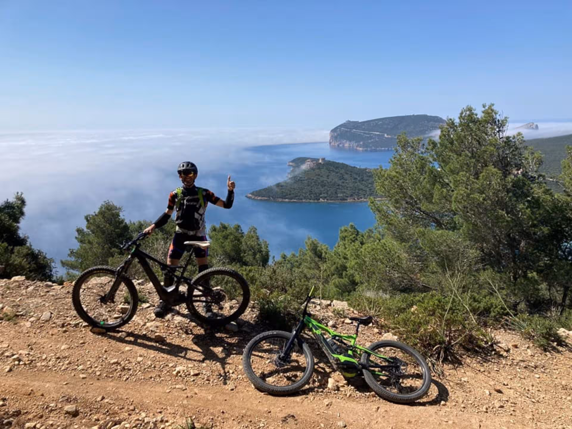 E-bike tour participant overlooking stunning coastal views in Porto Conte Park, Alghero.