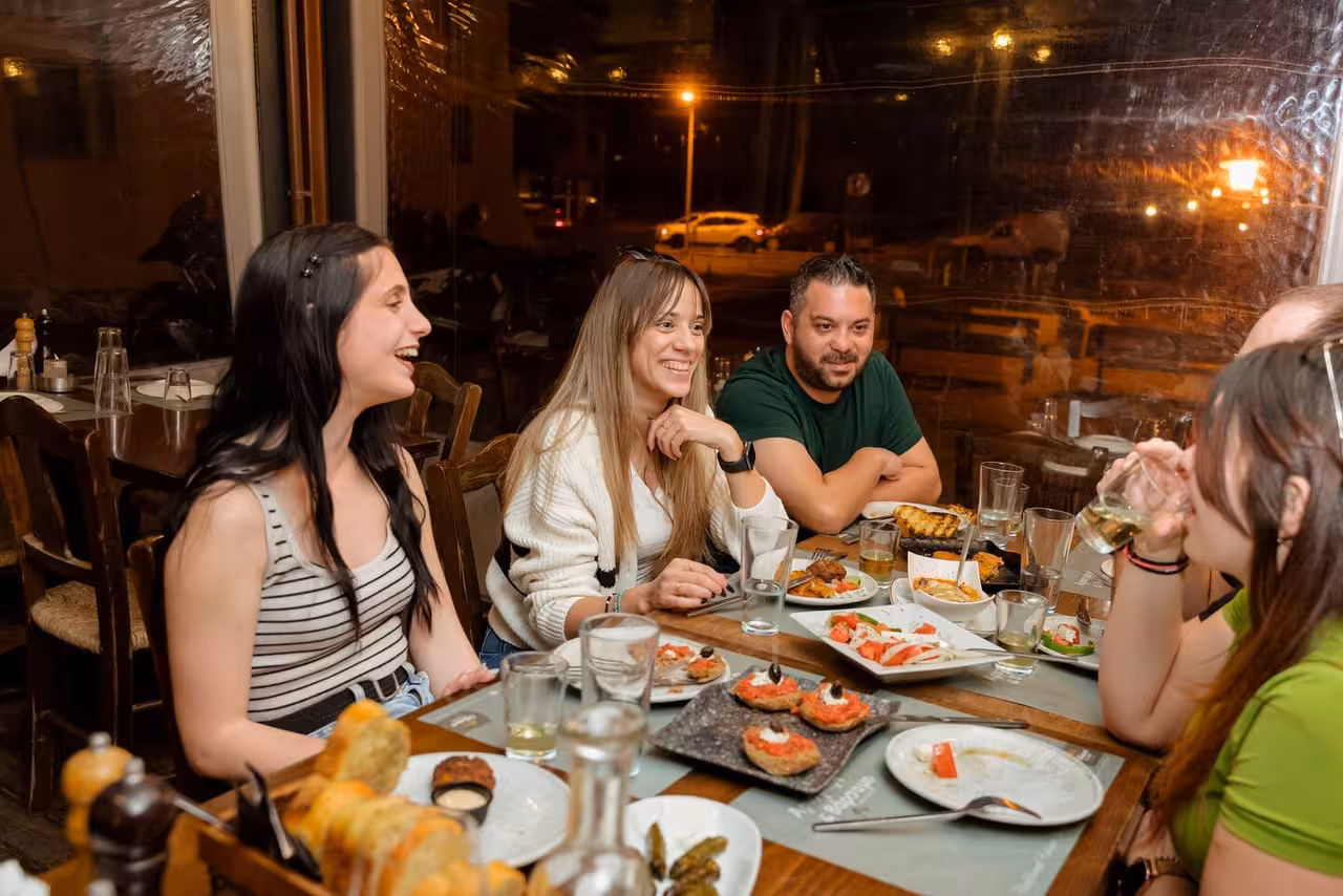 Group shares Cretan meze and local wine tasting at a taverna, part of the Eco Bike Full Day Tour in Crete