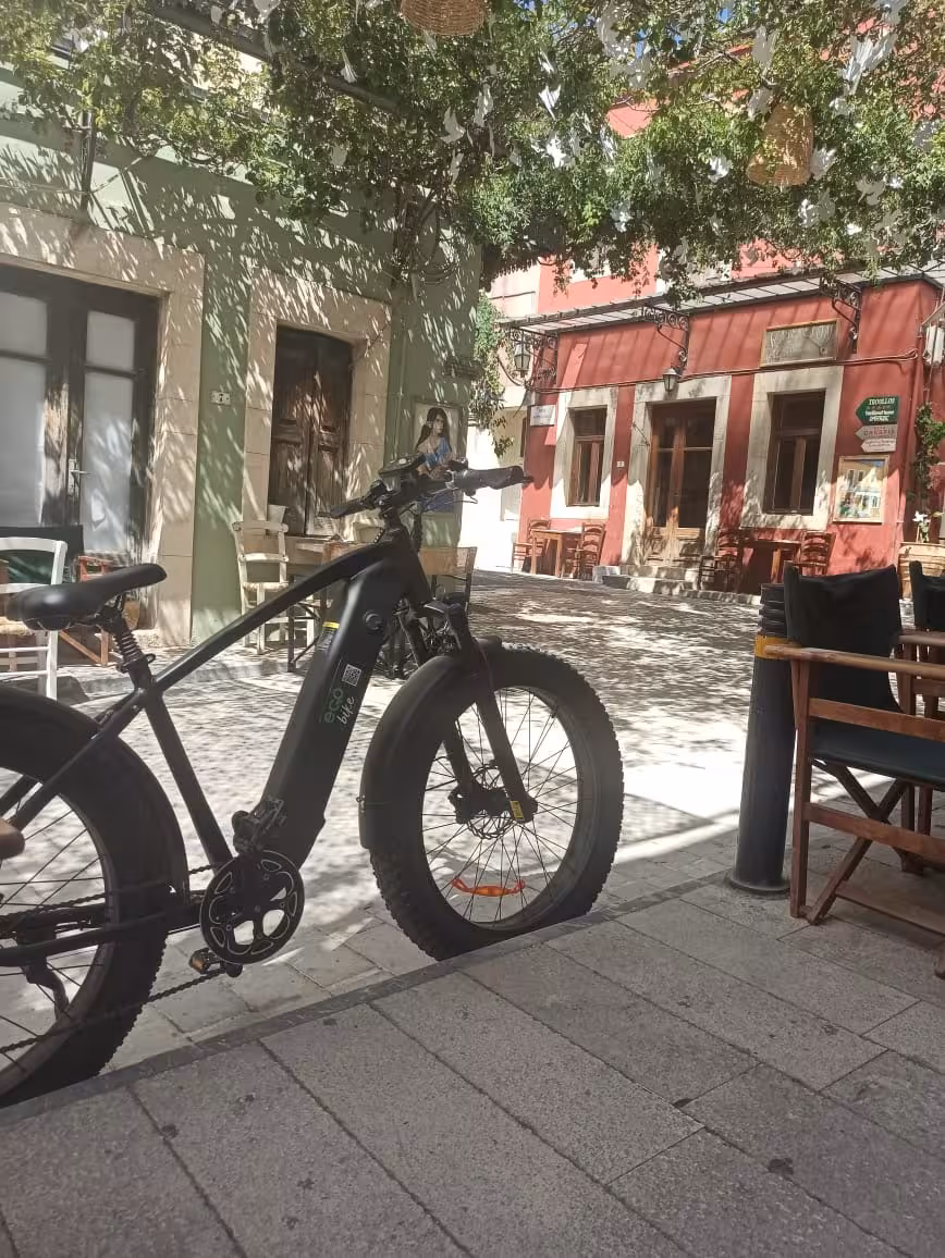 Ecobike e-bike parked in a shaded Cretan village square, ideal stop on full-day Crete food tasting tour