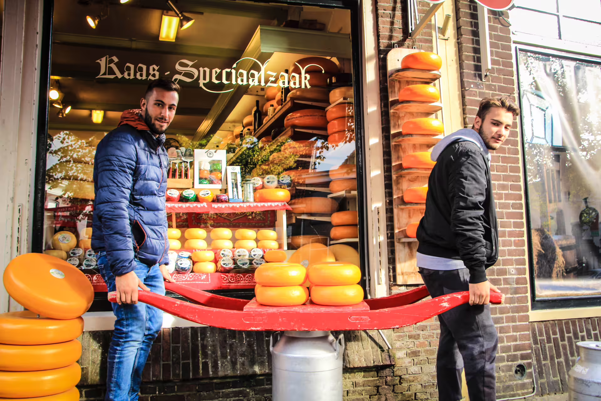 Visitors exploring a traditional cheese shop in Edam with vibrant wheels of Dutch cheese on display, perfect for a Zaanse Schans tour.