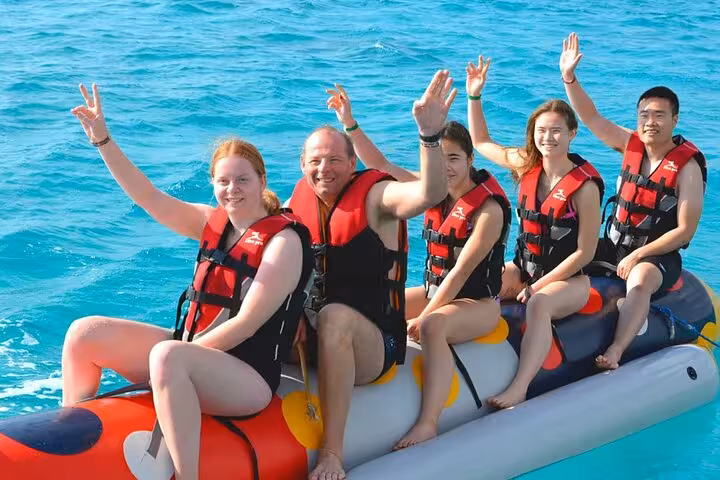 Group riding banana boat in the Red Sea on Eden Island day trip from Hurghada with water sports and lunch