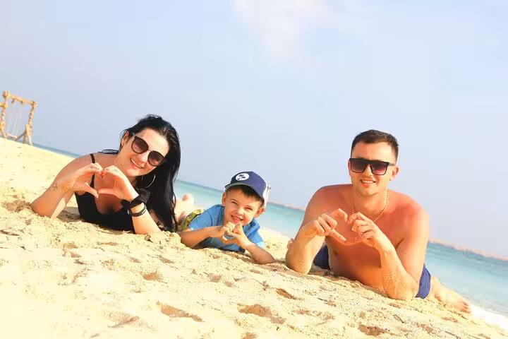 Family relaxing on Eden Island beach from Hurghada, Red Sea day trip with snorkeling, water sports and lunch